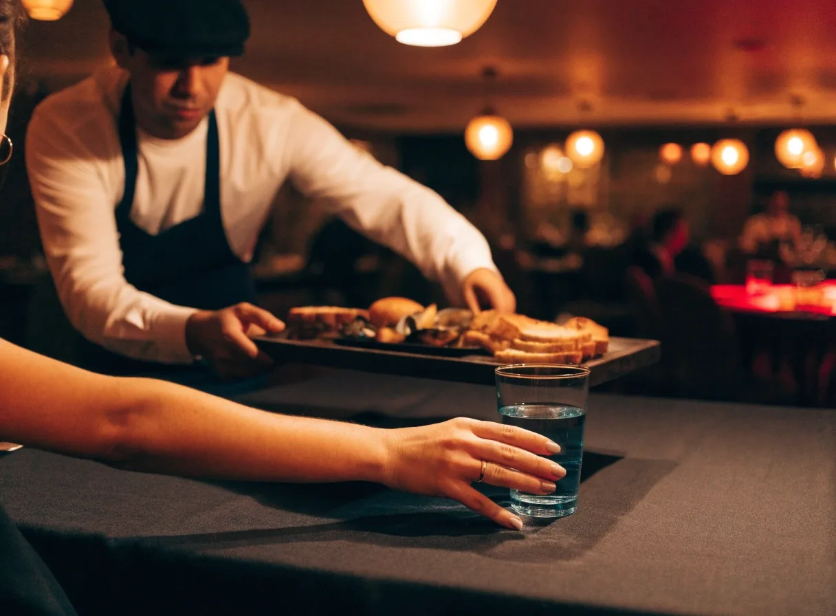 Przekąski do dzielenia i danie główne na ciemnym stole w restauracji